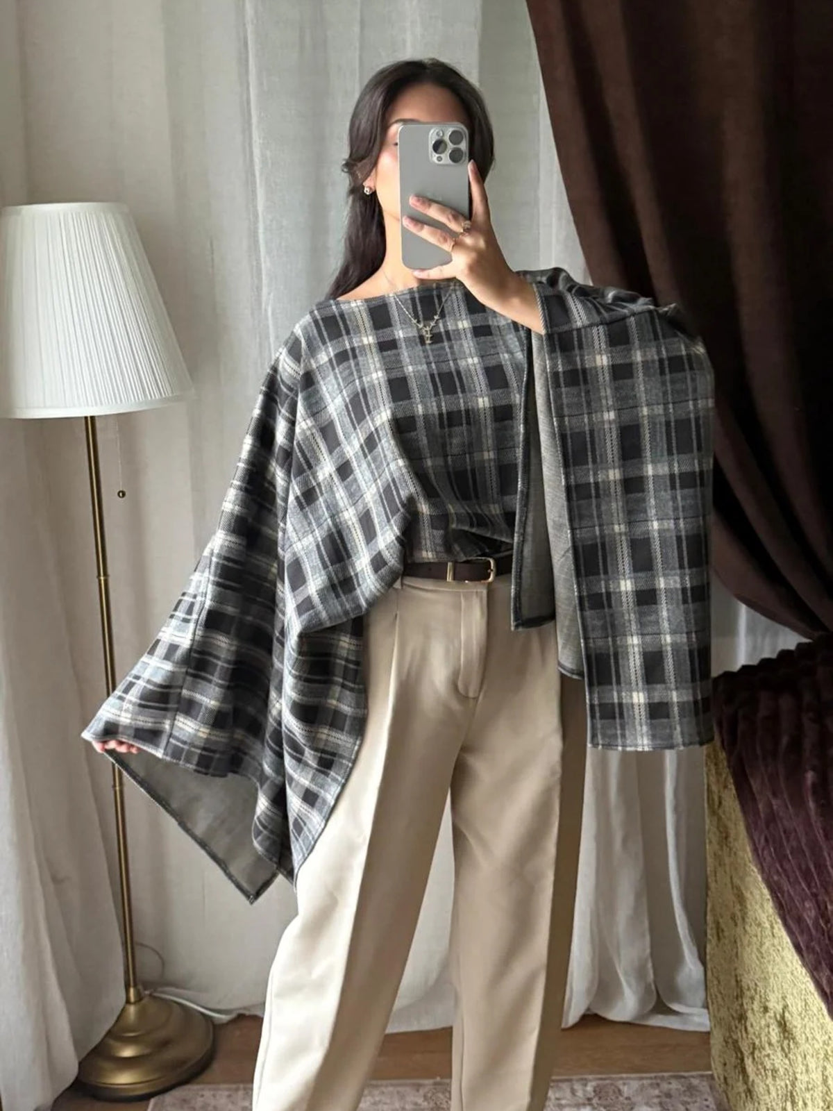 Cape à carreaux noir et gris portée avec un pantalon beige
