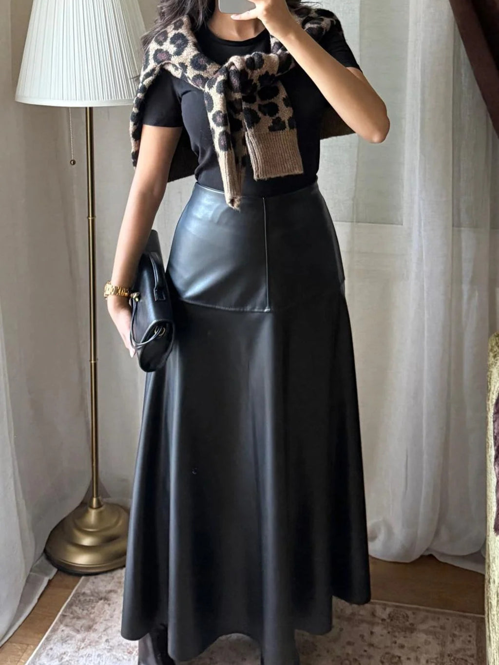 Jupe longue simili cuir noire portée avec un t-shirt noir