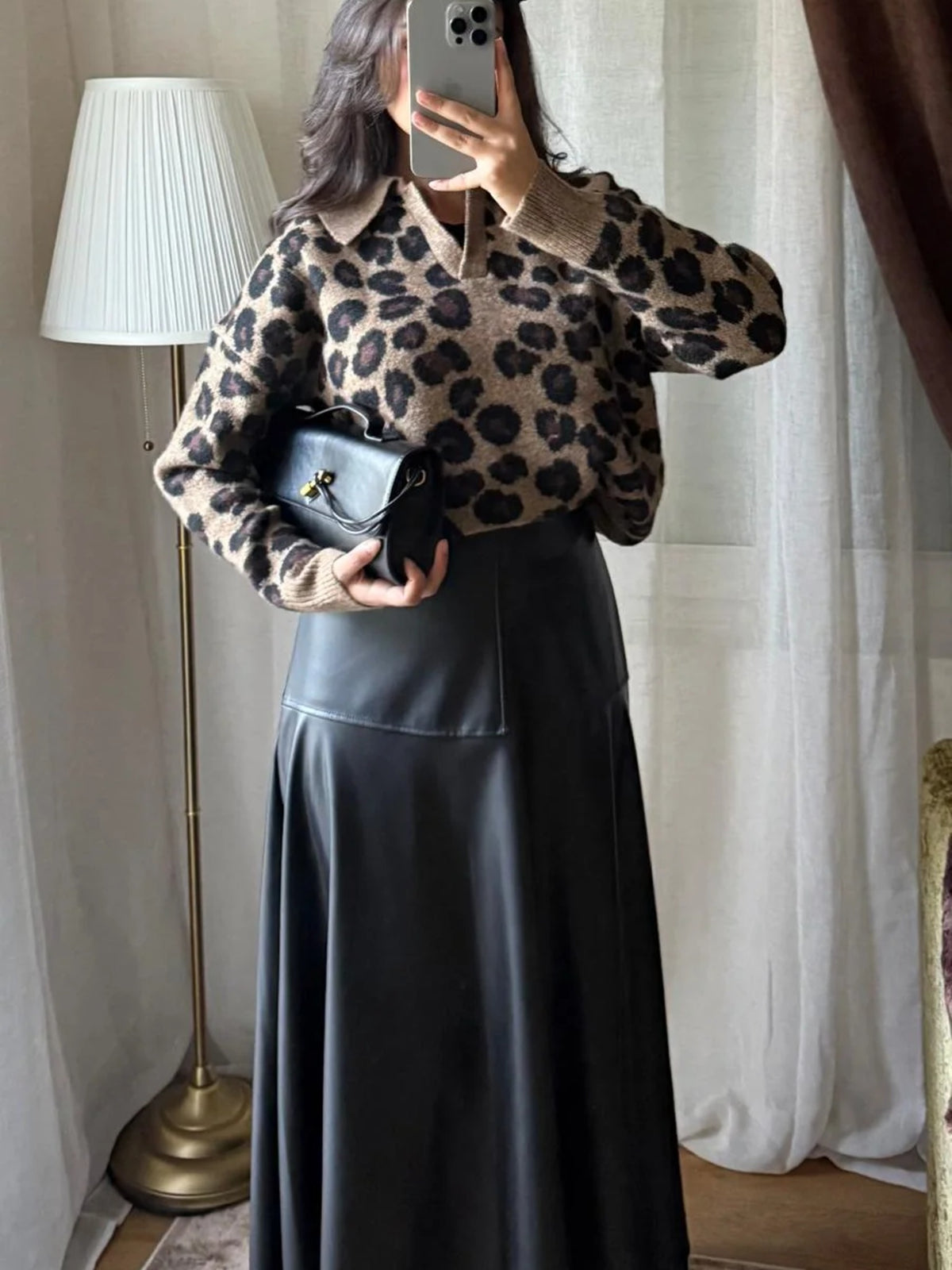 Pull léopard porté avec une jupe longue simili cuir noire
