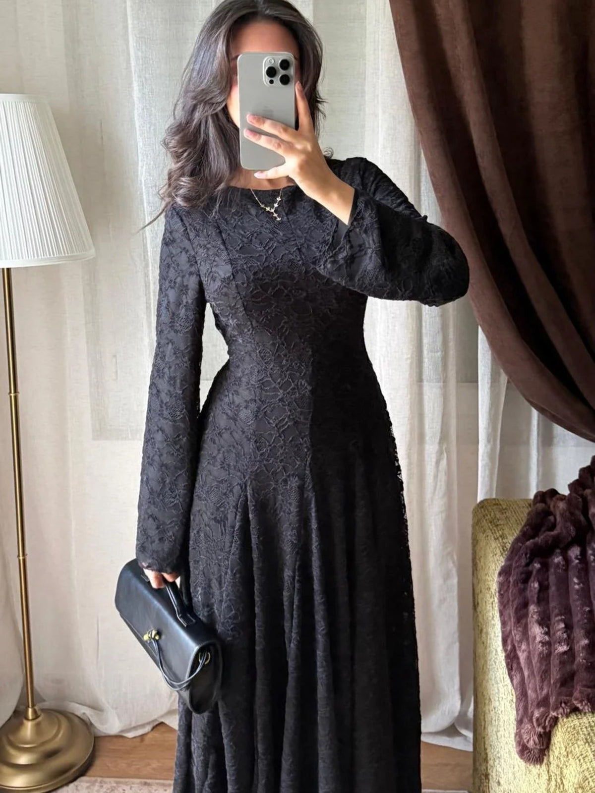 Robe longue en dentelle noire portée de face