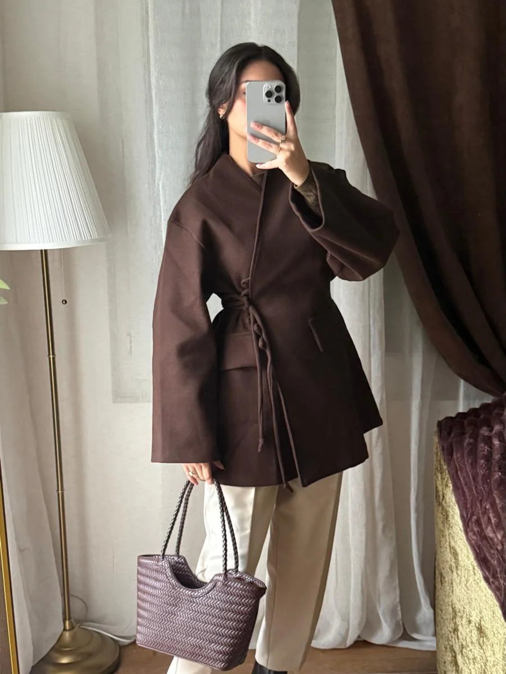 Veste croisée ceinturée chocolat portée avec un pantalon beige