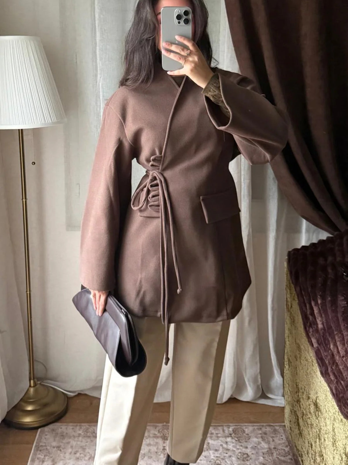 Veste à laçage marron portée avec un pantalon beige
